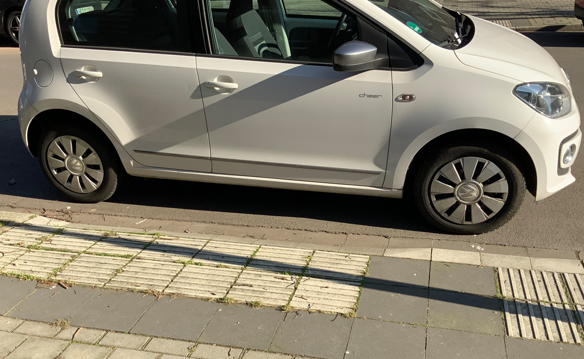 Auto parkt einen Blindenübergang zu